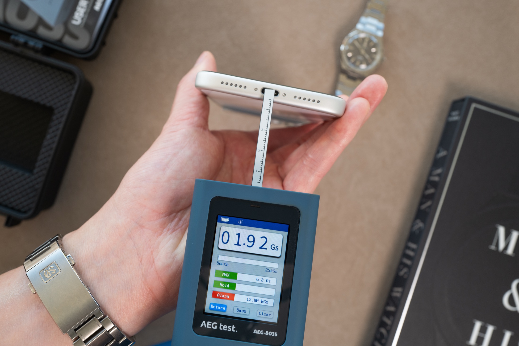 Gaussmeter probe measuring iPhone bottom edge center, display showing 1.92 Gauss